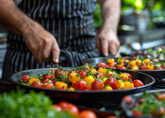 A man is cooking tomatoes in a pan in a kitchen, surrounded by various food items like fruits and ingredients for a delicious dish preparation